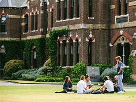 Students enjoying the picturesque Ƶ grounds in front of the most historic building